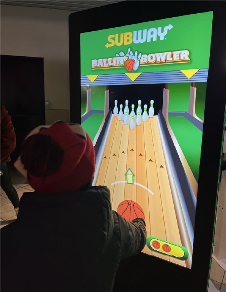 An interactive kiosk for a Subway activation attracts attention at a Raptors game